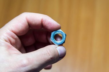 Elinde büyük metal bir fındık var. Erkek eli.