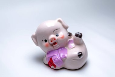 Beyaz arka planda pembe yuvarlak ve komik oyuncak domuz.