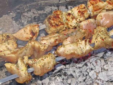 Kızarmış tavuk eti ateşte. Çiftlik barbeküsü, kömür ve yiyecek