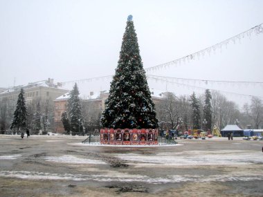 Şehrin merkez meydanında Noel ağacı ve kar