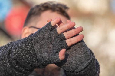 Adam elleriyle yüzünü kapatıyor ve fotoğrafının çekilmesini istemiyor.