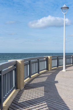 Fenerli deniz seti. Turistlerin dinlenebileceği ve deniz boyunca yürüyebileceği bir yer. Sahil şeridi boyunca kaldırım. Deniz manzaralı yeni bir set. Ampul direkleri korkuluklarda.
