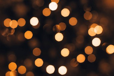 Karanlık bir arkaplanda bir Noel ağacının üzerindeki bulanık bir çelenk. Noel ve yeni yıl arkaplanı. Odaklanma, kopyalama alanı..
