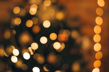 Karanlık bir arkaplanda bir Noel ağacının üzerindeki bulanık bir çelenk. Noel ve yeni yıl arkaplanı. Odaklanma, kopyalama alanı..