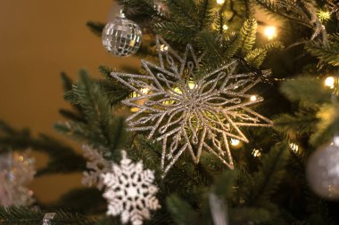 Beyaz ve gümüş Noel süslemeleri ile süslenmiş Noel ağacı, yakın plan. Yeni yılın arka planı. Sığ alan derinliği olan seçici odak.