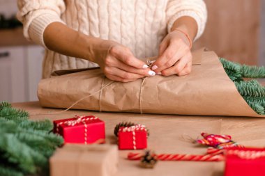 Evde köknar dallarından bir buket yapma süreci, kraft kağıdına sarma, kadının ellerine yakın çekim. Yeni yıl, Noel ve çevre dostu kavram. Seçici odaklanma..