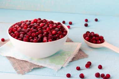 Mavi masa üzerinde kase dondurulmuş kızılcık
