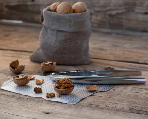 Nutcracker with walnuts on wooden background — Stock Photo, Image