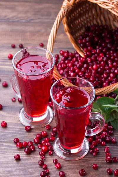 Suco de cranberry orgânico em copos com bagas em fundo de madeira — Fotografia de Stock