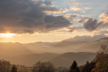 Sonbaharda dağlarda sis. Akşam güneşi vadileri aydınlatıyor. Fransa Avrupa, Vosges.