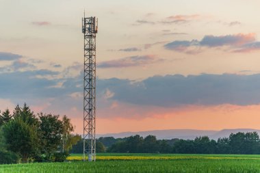 Yazın gün batımında kırsalda telekom anteni. Alsace, Fransa.
