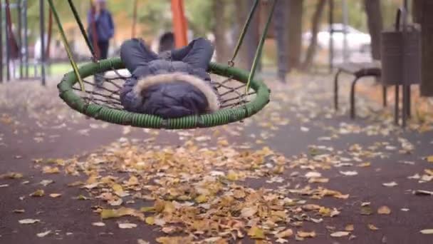 Sfondo Autunnale Sfocato Con Bambina Giacca Cappello Che Cavalca Altalena — Video Stock