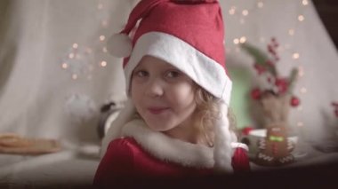 Noel Baba şapkalı bulanık küçük kız Noel 'in tadını çıkarıyor. Xmas Çocukluk Tatili Konseptini Sunar. 