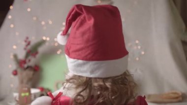 Noel Baba şapkalı bulanık küçük kız Noel 'in tadını çıkarıyor. Xmas Çocukluk Tatili Konseptini Sunar. 