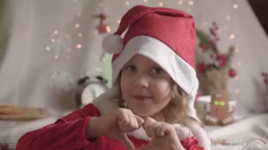 Noel Baba şapkalı bulanık küçük kız Noel 'in tadını çıkarıyor. Xmas Çocukluk Tatili Konseptini Sunar. 