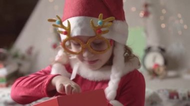 Noel Baba şapkalı bulanık küçük kız Noel 'in tadını çıkarıyor. Xmas Çocukluk Tatili Konseptini Sunar. 