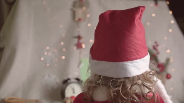 头戴圣诞礼帽的小女孩迷糊了 享受着圣诞时光 圣诞佳节推出童年时期的概念 — 图库视频影像
