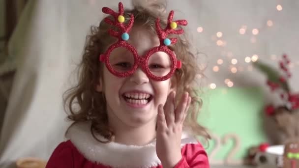 Niña Borrosa Rizada Poniéndose Gafas Navidad Mirando Cámara Sonriendo Navidad — Vídeo de stock