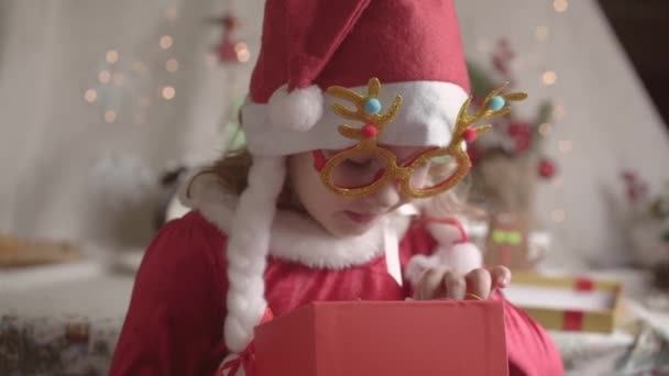 Zamazana Dziewczynka Kapeluszu Mikołaja Ciesząca Się Gwiazdką Boże Narodzenie Prezentuje — Wideo stockowe