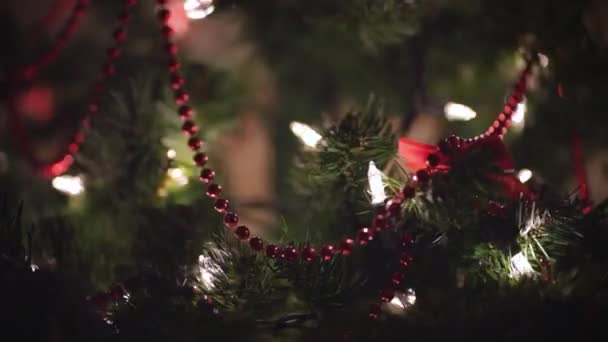 美しい装飾されたクリスマスツリーには 夜のリビングルームにはボケのライトが飾られています 新年の準備と待っているという概念 — ストック動画