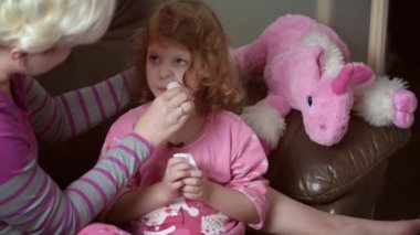 Burun aspiratörü kullanan bir annenin bulanık görüntüsü. Kızı sümüklü..