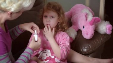 Burun aspiratörü kullanan bir annenin bulanık görüntüsü. Kızı sümüklü..