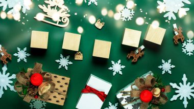 Noel süslemesinden yapılmış Noel kompozisyonu ve yazı veya metin yeşili arka plan için beş tahta küp. Noel ve Yeni Yıl 'ın minimum konsepti. Yüksek kalite fotoğraf