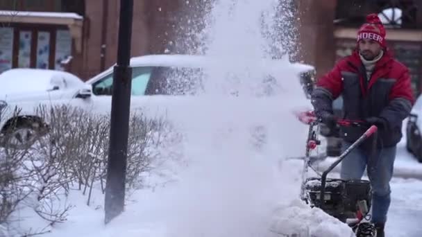 激しい雪の天候の背景に道路から白い雪を削除する冬には雪のぬかるみトラクターが吹い 寒い季節の環境で街中で雪が積もるプロセスのクローズアップ — ストック動画