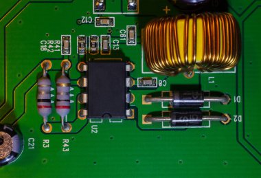 Bilgisayar (CPU) kontrolü için bakır bobin sarmalının yakın çekim makro görüntüsü, video kartı kontrol panelinin bir parçası olan elektronik baskılı devre (PCB) üzerindeki kuvars saat.