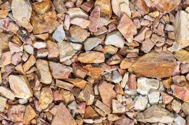 Yol yapımı için büyük, ezilmiş bir taş. Kırmızı moloz kaldırım arka planı.