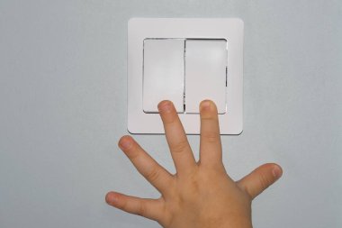 Çocuğun eli ışığı yakar. Çocuğun yüksekliğinde bir ışık düğmesi. Elektriği açıp kapamak için aç.