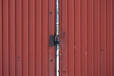 Paslı, eski, demir gibi bir kırmızı kapıdaki kale. Kapalı fabrika. Metalik arkaplan.