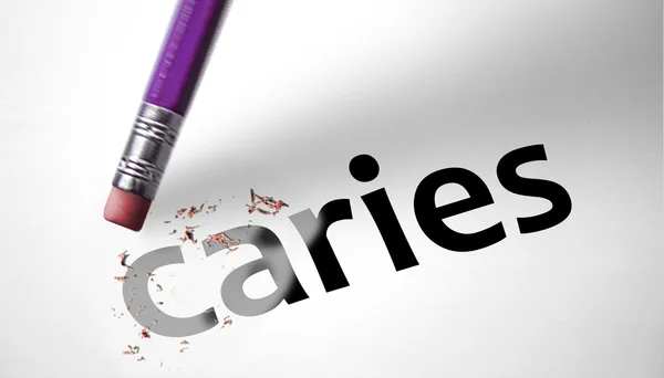 Eraser deleting the word Caries — Stock Photo, Image