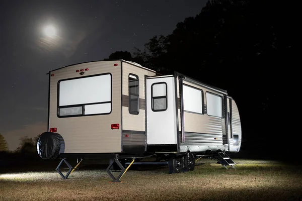 Travel trailer with slides out and moon and stars above