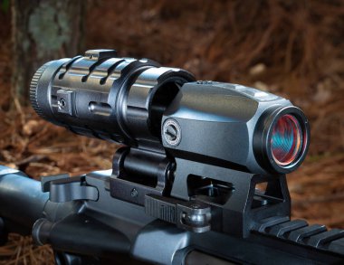 Ormandaki bir AR-15 'te büyüteç ve kırmızı nokta görüşü.