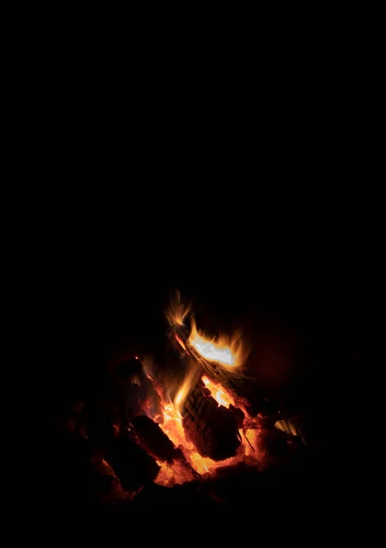 Vertical image of a campfire below with black space above for text