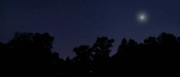 Christmas star over Raeford North Carolina with a silhouetted forest