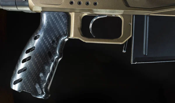 Trigger with pistol grip and magazine on a rifle on a black background