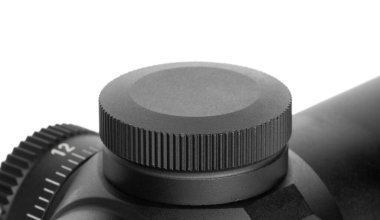 Beyaz renkte izole edilmiş bir silah dürbünündeki rüzgar ayarlarını kaplayan kapak