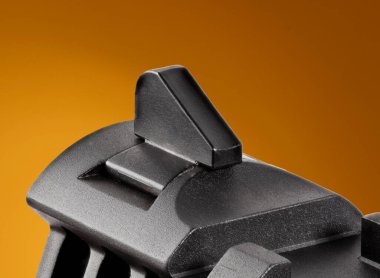 Turuncu arka planı olan bir tabancanın ön görüşü.