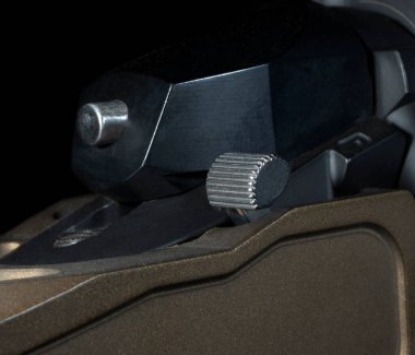 Siyah arka planı olan bakır renkli bir tüfeğe bağlı güvenlik.