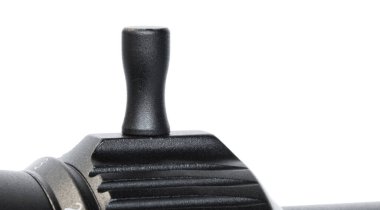 Tüfek dürbünündeki hız kolu beyaza izole edilmiş.