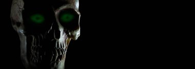 Siyah üzerinde kopya alanı olan parlayan yeşil gözlü kafatası