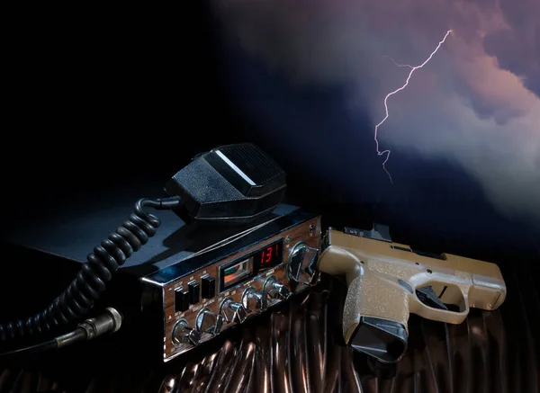 Gun and CB radio with lightning storm behind