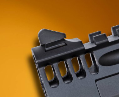 Limanlara yakın görüş ve büyük yarı otomatik bir tabanca, bronz ve turuncu bir arka planı var..