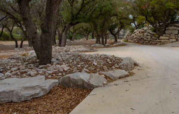 Rock and tree lined driveway made from concrete