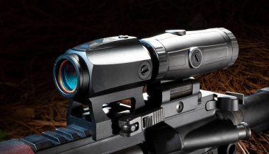 Dışarıdaki bir saldırı tüfeğinde kırmızı noktanın arkasındaki büyüteç.