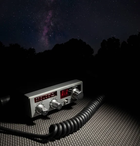 Two way radio with microphone cord and Milky Way behind at night