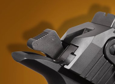 Turuncu arka planda yarı otomatik bir çekicin arkasına gölge düşür.