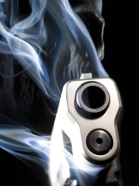 Siyah arka planda namlu ve kafatasından yükselen dumanlı 3 boyutlu bir hayalet silah.